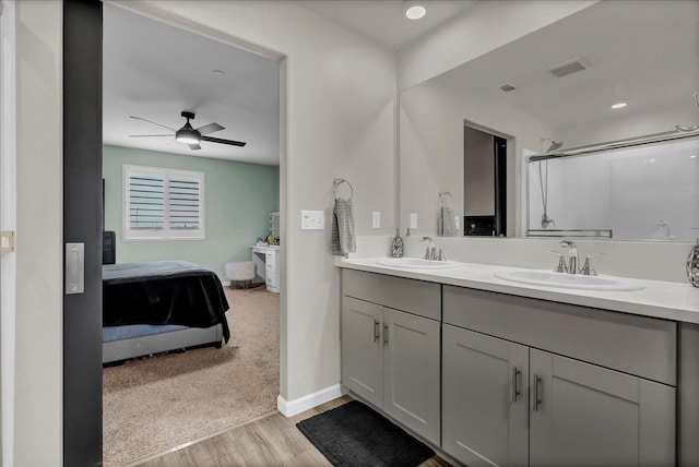 bathroom with ceiling fan, vanity, a shower with shower door, and hardwood / wood-style floors