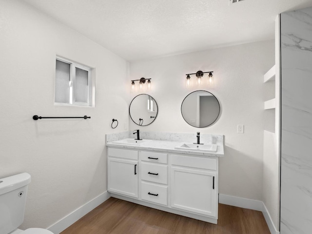 bathroom with toilet, hardwood / wood-style floors, and vanity