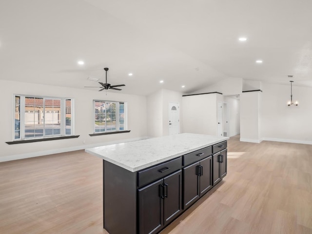 kitchen with light hardwood / wood-style floors, ceiling fan, vaulted ceiling, a kitchen island, and pendant lighting