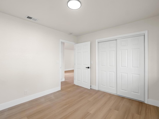 unfurnished bedroom featuring light hardwood / wood-style floors and a closet