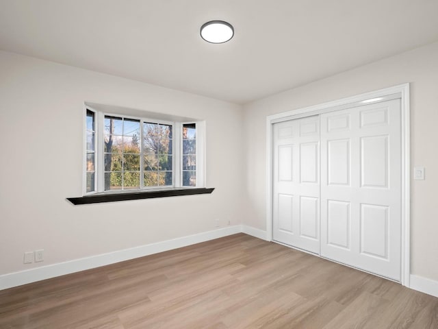 unfurnished bedroom featuring a closet and light hardwood / wood-style floors