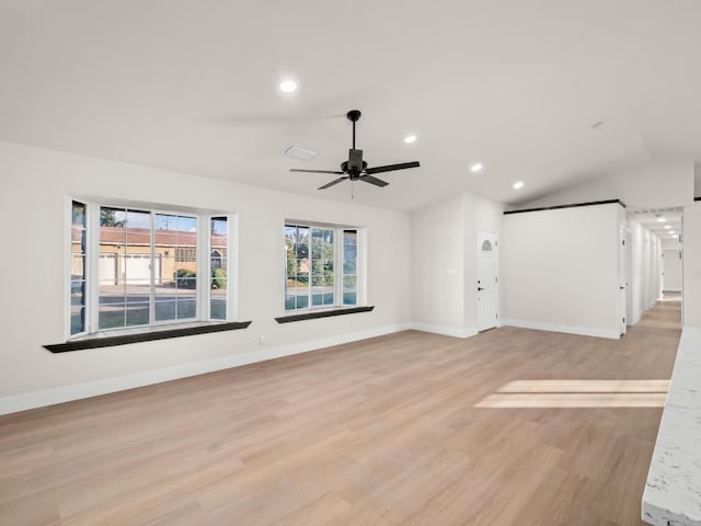 unfurnished living room featuring ceiling fan, vaulted ceiling, and light hardwood / wood-style flooring