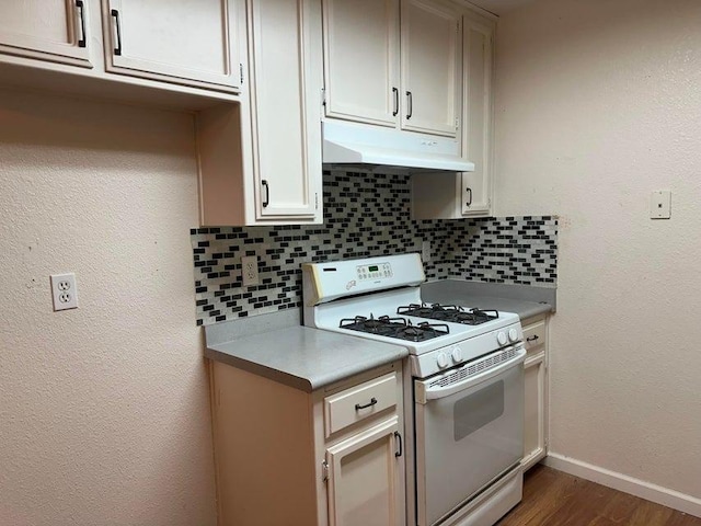 kitchen featuring decorative backsplash, dark hardwood / wood-style floors, white cabinetry, and white gas range oven