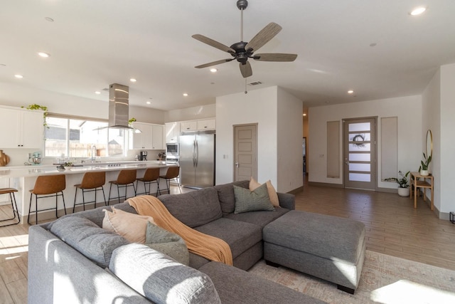 living room with ceiling fan and light hardwood / wood-style flooring