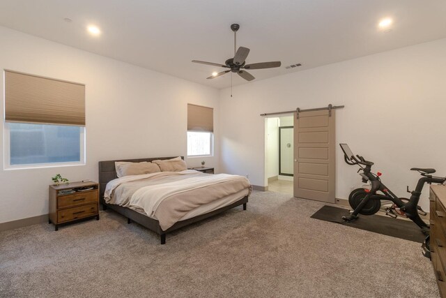 carpeted bedroom featuring ceiling fan and a barn door