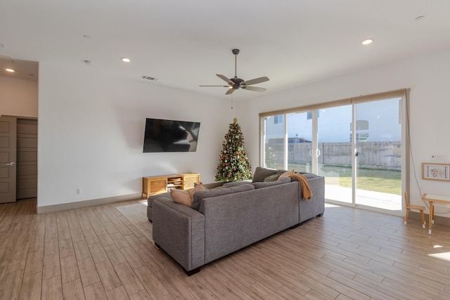 living room featuring ceiling fan and light hardwood / wood-style floors