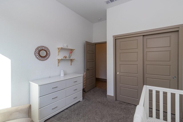 unfurnished bedroom with a crib, carpet, and a closet