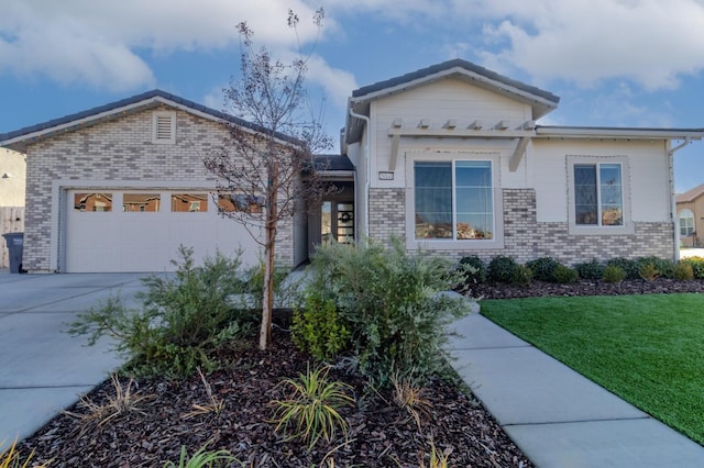 view of front of property with concrete driveway, an attached garage, brick siding, and a front lawn