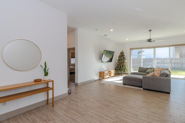 living room with ceiling fan and light wood-type flooring