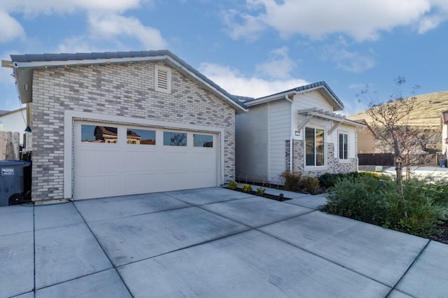 view of front of property featuring central air condition unit, brick siding, concrete driveway, and an attached garage