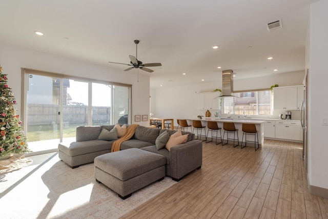 living room featuring ceiling fan and light hardwood / wood-style flooring