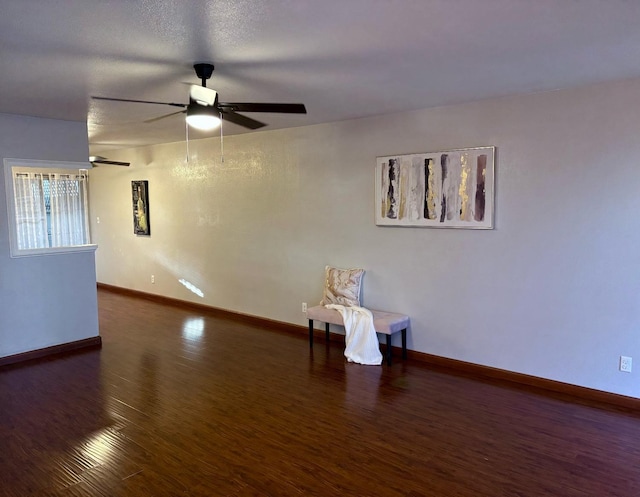 empty room with ceiling fan and dark wood-type flooring