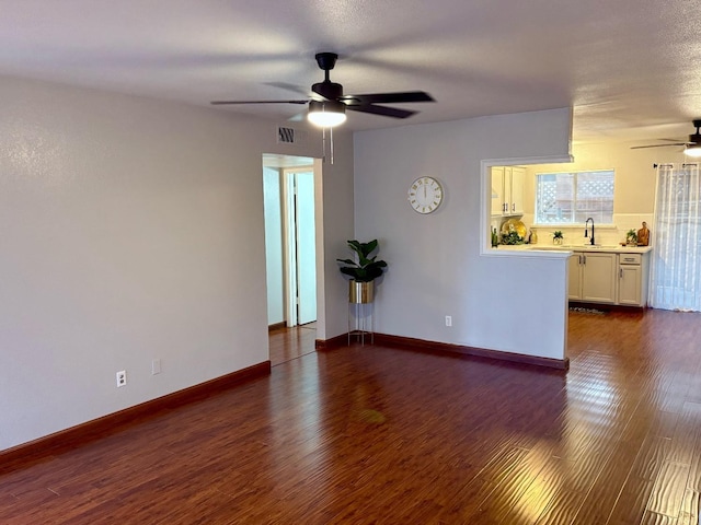 unfurnished room with ceiling fan, dark wood-type flooring, and sink