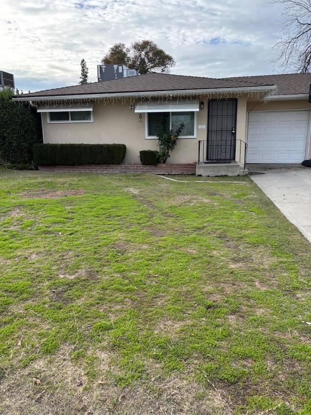 ranch-style home with a garage and a front lawn