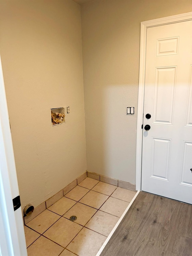 clothes washing area with hookup for a washing machine, laundry area, baseboards, and light tile patterned floors