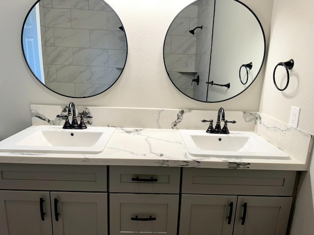 bathroom with a textured wall, a sink, and double vanity