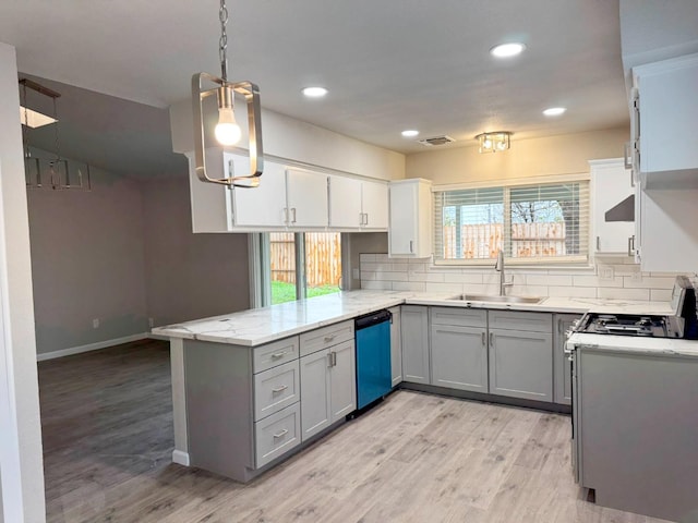 kitchen featuring hanging light fixtures, gray cabinetry, a sink, dishwasher, and a peninsula