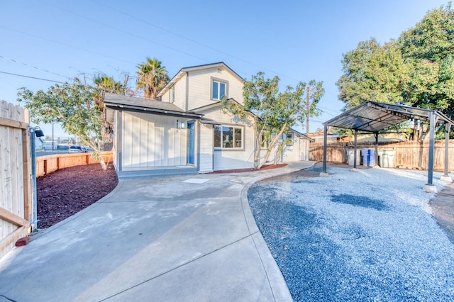 back of house featuring a carport