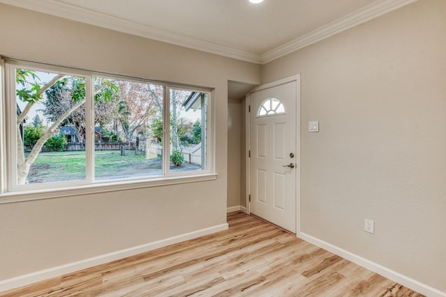 entryway featuring ornamental molding and light hardwood / wood-style flooring