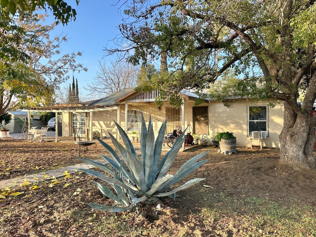 1554 W Thomas Ave, Fresno, CA 93728 - view of front facade with stucco siding, cooling unit, and a patio