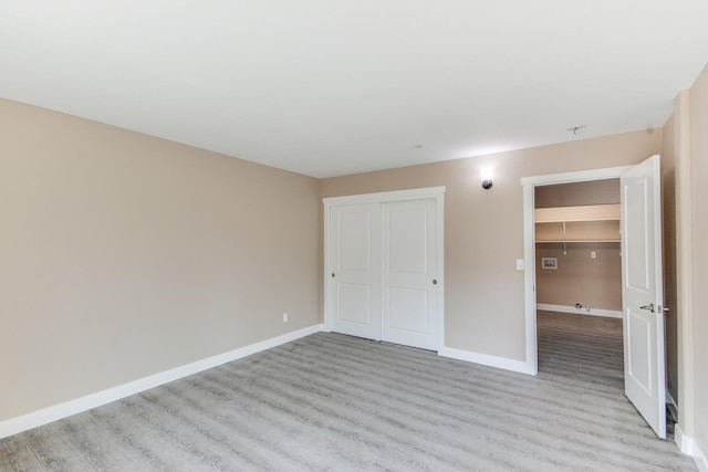 unfurnished bedroom featuring a closet and light wood-type flooring