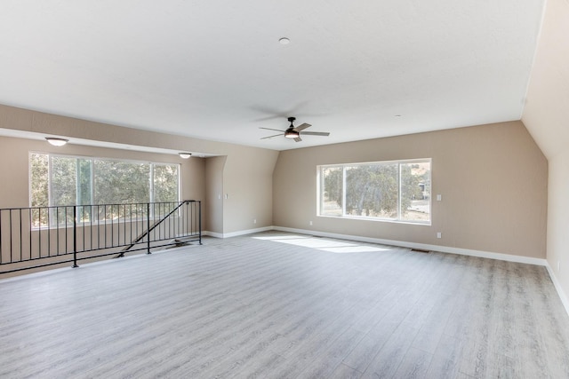 unfurnished room with ceiling fan, light hardwood / wood-style floors, and lofted ceiling