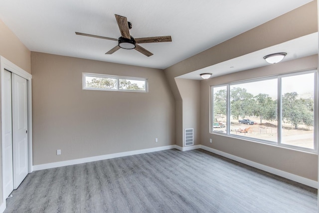 unfurnished bedroom featuring ceiling fan, a closet, and light hardwood / wood-style floors