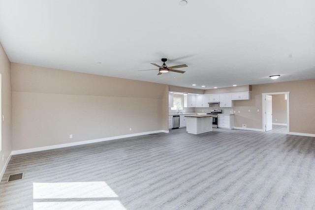 unfurnished living room with ceiling fan