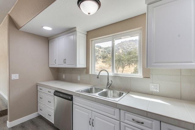 kitchen with dark hardwood / wood-style flooring, tasteful backsplash, stainless steel dishwasher, sink, and white cabinetry