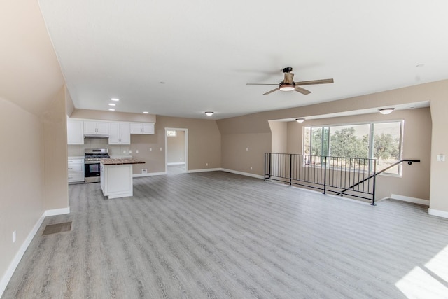 unfurnished living room with ceiling fan and light wood-type flooring