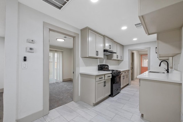 kitchen featuring sink, light colored carpet, and black range with gas cooktop