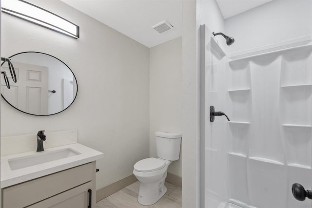 bathroom with vanity, toilet, and a shower