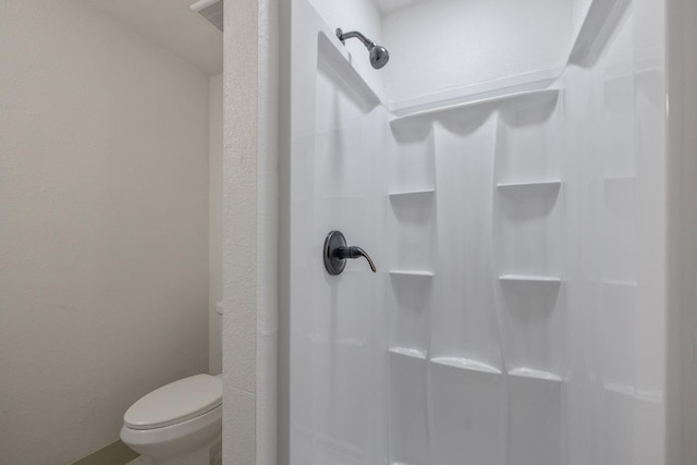 bathroom with a shower and toilet