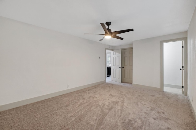 carpeted spare room featuring ceiling fan