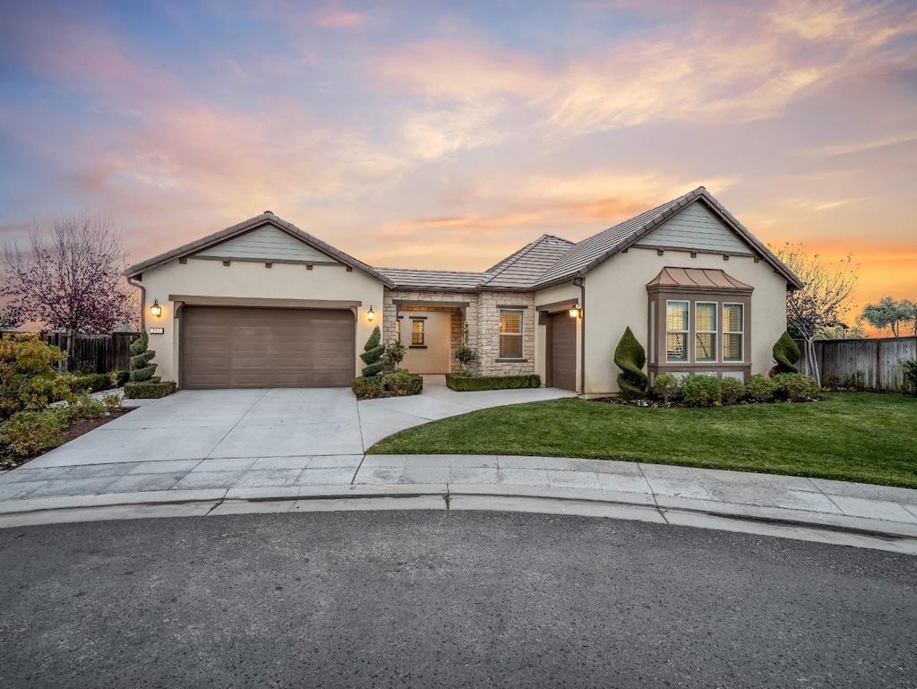 view of front of home with a garage and a yard