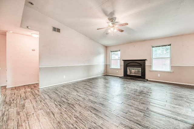 unfurnished living room with wood-type flooring, vaulted ceiling, and ceiling fan