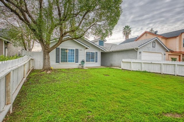 back of house with a lawn and a garage