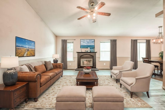 living room featuring a wealth of natural light and ceiling fan with notable chandelier