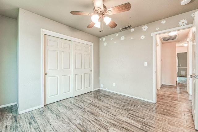 unfurnished bedroom featuring ceiling fan, a closet, and light hardwood / wood-style floors