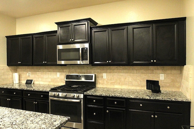 kitchen with tasteful backsplash and appliances with stainless steel finishes