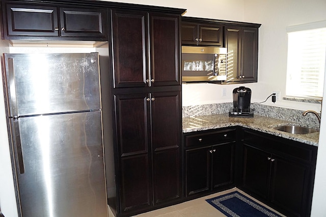 kitchen with light stone counters, stainless steel appliances, and sink