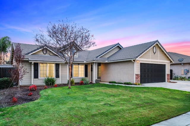 ranch-style house featuring a yard and a garage