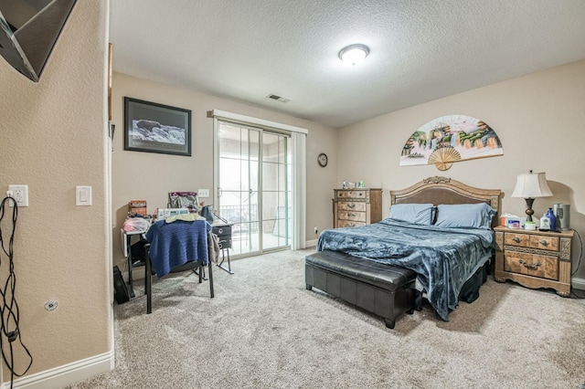 carpeted bedroom with access to exterior and a textured ceiling