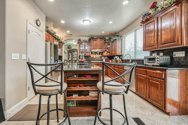 kitchen featuring dishwasher, sink, a textured ceiling, and tasteful backsplash