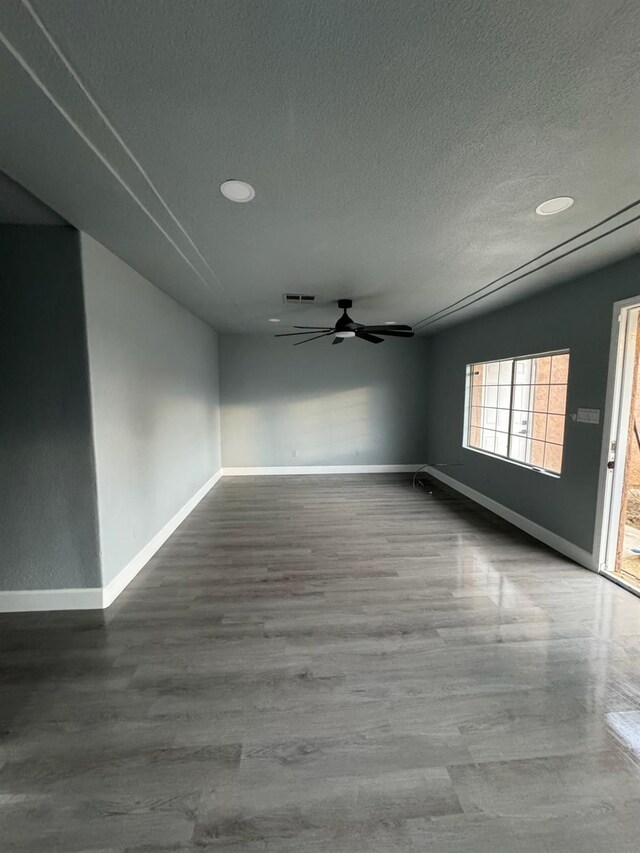 empty room featuring a textured ceiling, hardwood / wood-style flooring, and ceiling fan