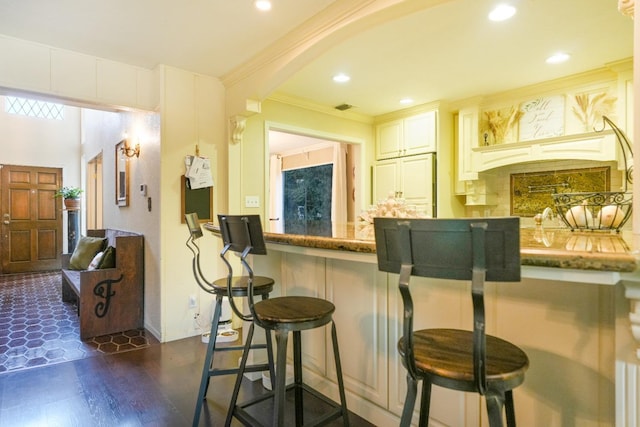 bar with white cabinetry, crown molding, dark stone counters, and dark hardwood / wood-style floors