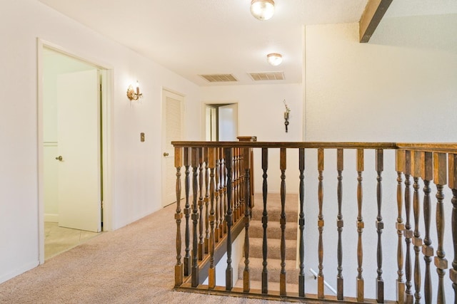 corridor featuring light carpet and beamed ceiling