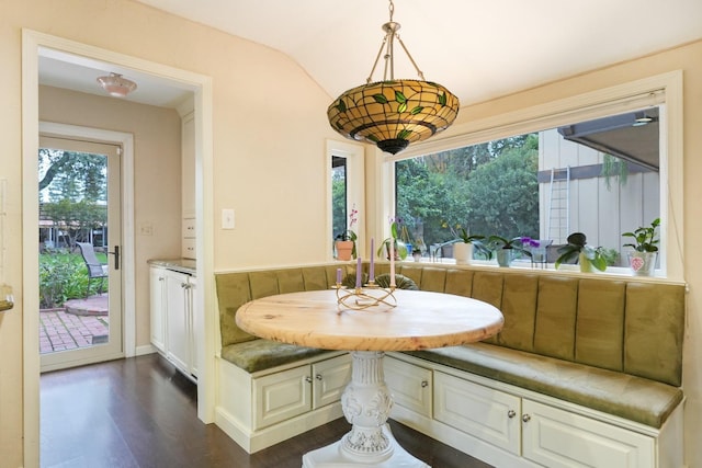 dining room with vaulted ceiling, breakfast area, and dark hardwood / wood-style floors