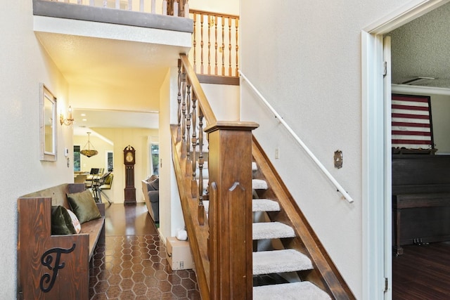 stairway featuring tile patterned flooring and a textured ceiling