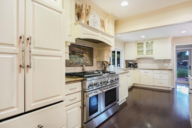 kitchen with decorative backsplash, white cabinets, dark wood-type flooring, and range with two ovens